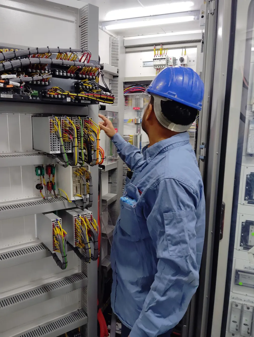 Installateur controleert de bekabeling in een schakelkast